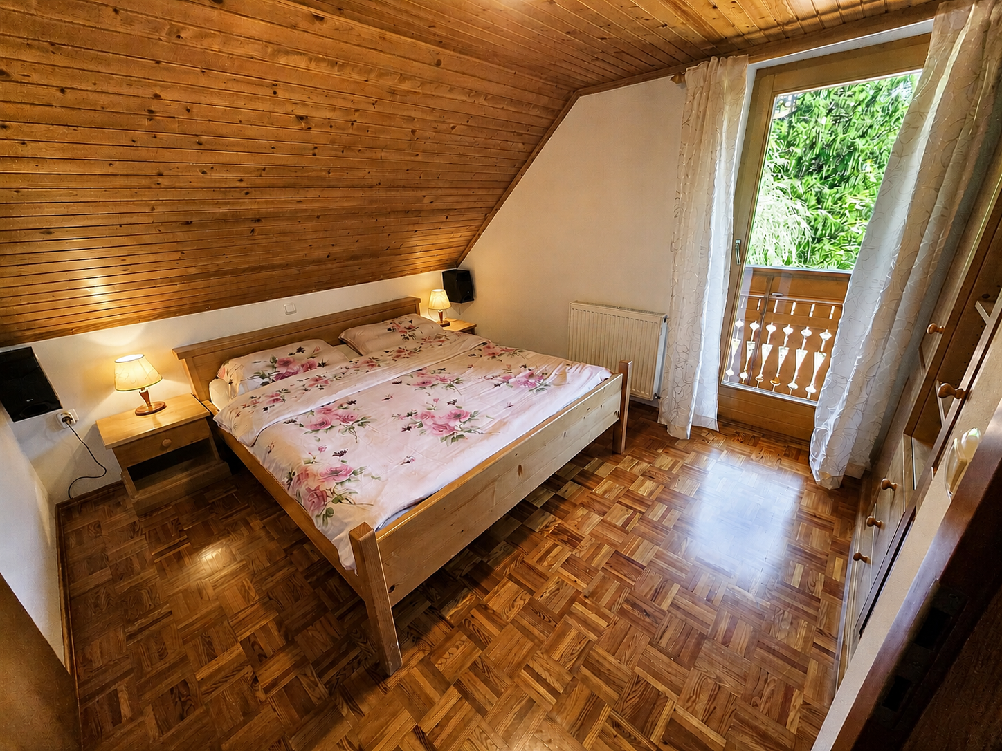 Spalnica 4 v leseni počitniški hiši — zakonska postelja in izhod na balkon