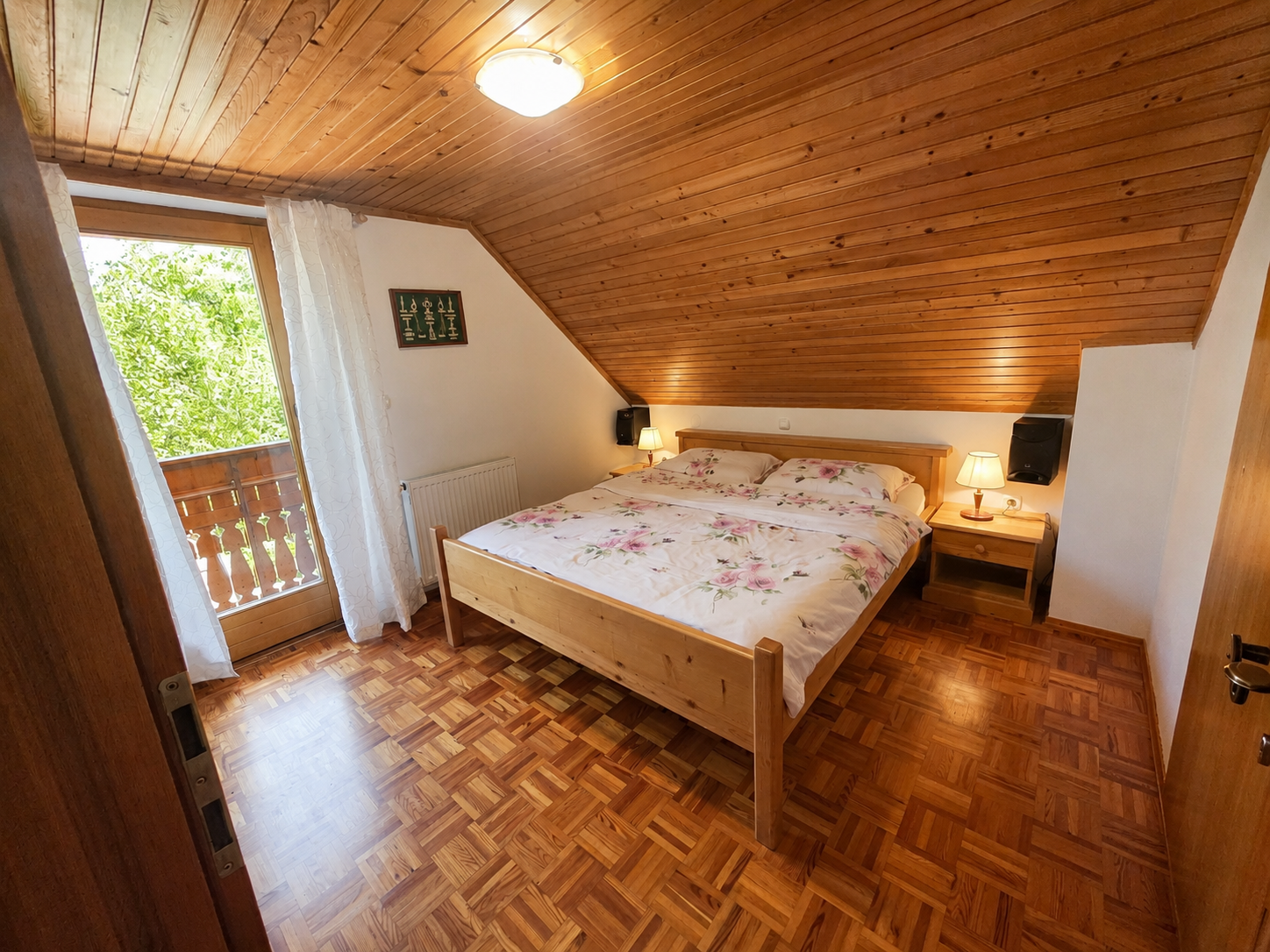 Spalnica 3 v leseni počitniški hiši — zakonska postelja in izhod na balkon