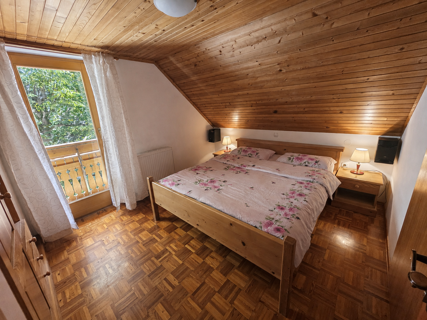 Spalnica 2 v leseni počitniški hiši — zakonska postelja in izhod na balkon